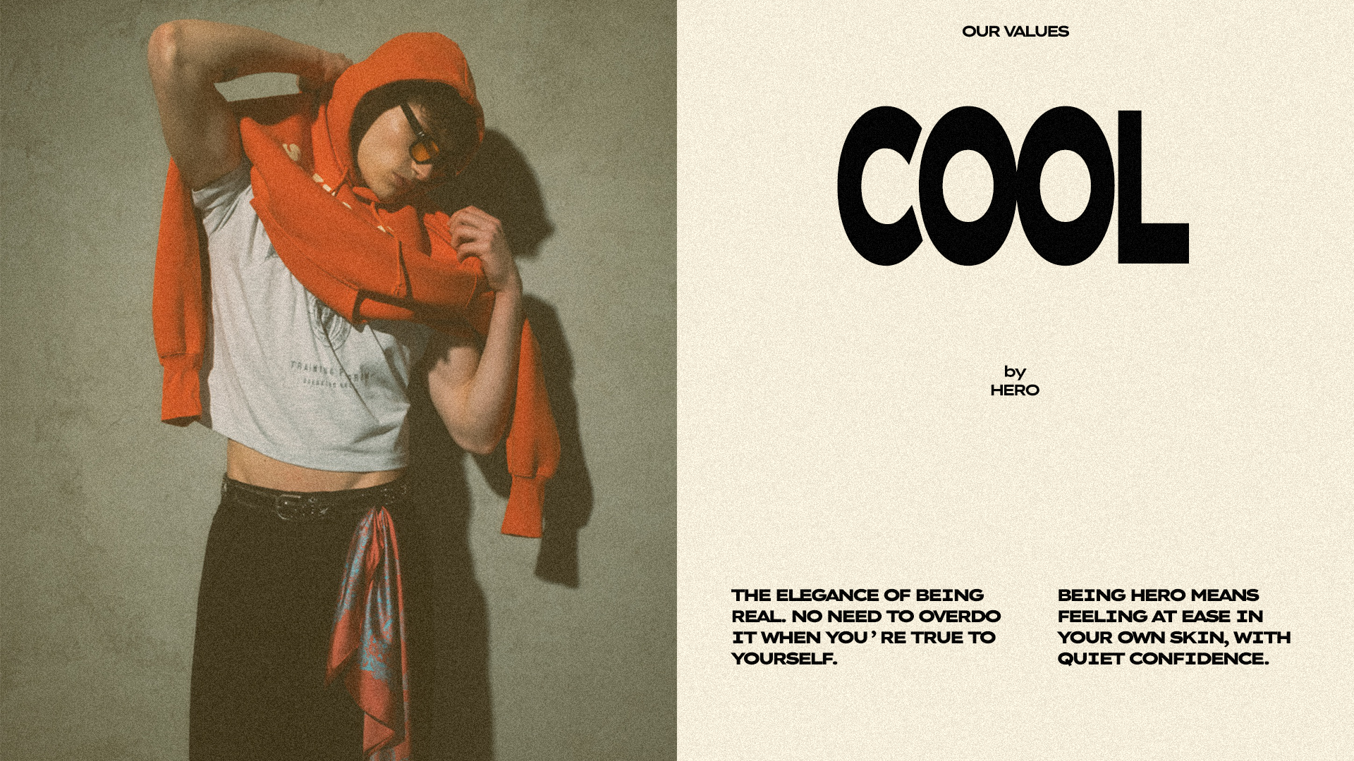 Modello HERO con t-shirt oversize, felpa rossa, e foulard paisley allacciato ai pantaloni in posa rilassata e autentica che riflette lo stile streetwear e i valori di self-confidence del brand.